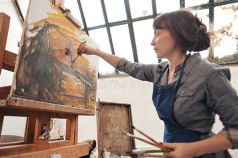 Woman Artist Fastens A Canvas On A Large Wooden Easel Stock Photo