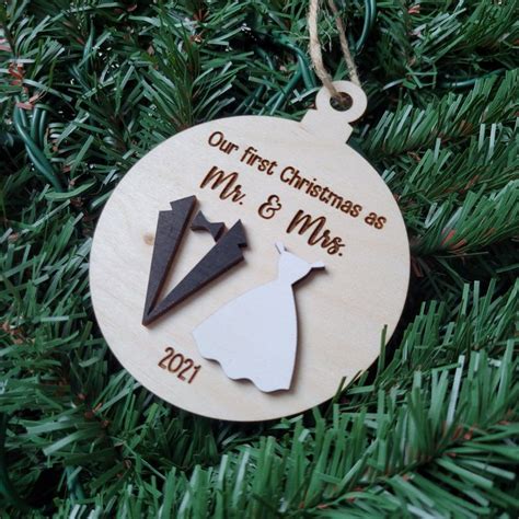 A Wooden Ornament Hanging On A Christmas Tree With The Words Our First