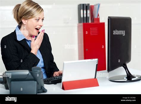 Surprised Female Secretary Looking At Lcd Screen Indoors Office Shot