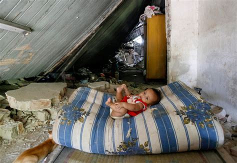 Mystylenews A Child Lies On A Mattress Inside A House Damaged By An