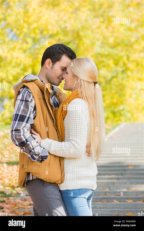 Couple Kissing In Park During Autumn Stock Photo Alamy