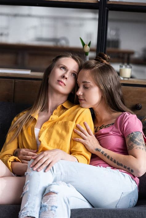 Dos Hermosas Lesbianas Abrazándose Mientras Se Sienta En El Sofá En La