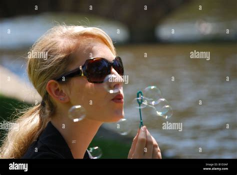Young Woman Blowing Bubbles Bourton On The Water Gloucestershire