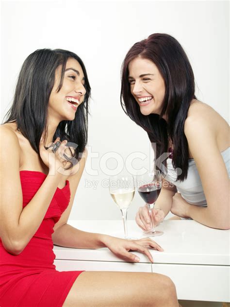 Two Beautiful Girls Chatting Laughing And Drinking Wine