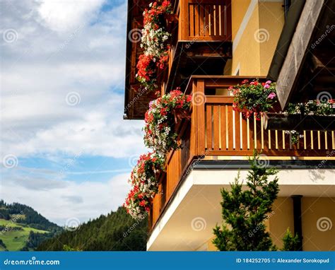 Potted Flowers On Balconies And Terraces Of Wooden Austrian Chalets In