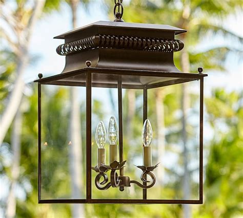 An Outdoor Hanging Lantern With Three Candles