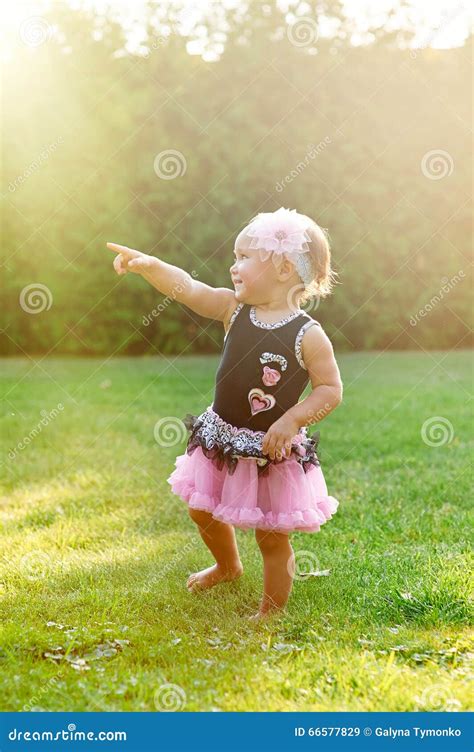 Счастливая маленькая девочка играя в луге лета на траве Стоковое
