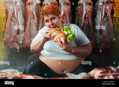 Fat Woman Eating Big Burger Against Meat Carcasses Overweight Concept Female Obesity Bulimic