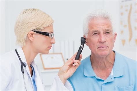Premium Photo Doctor Examining Male Patients Ear With Otoscope