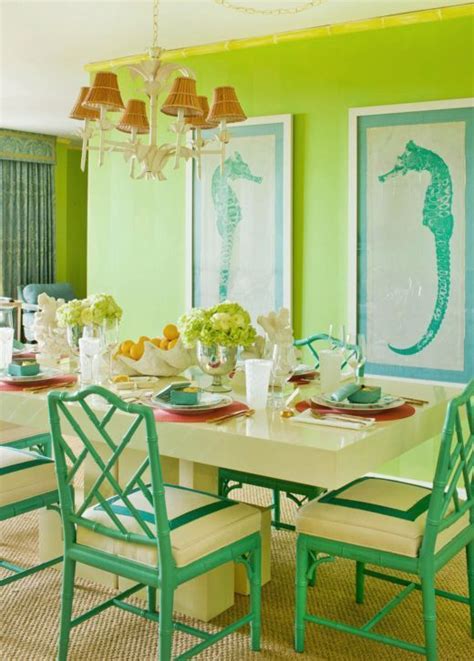 A Dining Room With Green Walls And Pictures On The Wall Above The