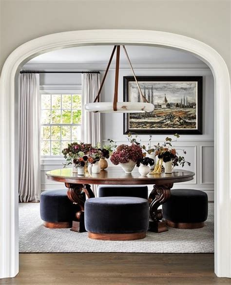 A Dining Room Table With Chairs And Vases On Top Of It In Front Of An