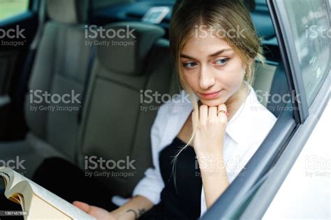 Beautiful Girl Reading Book In The Backseat Of The Car Stock Photo