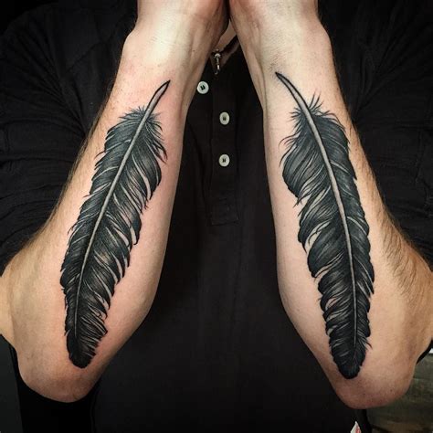 Two Mens Arms With Black Feathers On Them