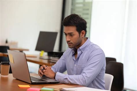 Portrait Of Young Business Indian Man Working With Laptop At Office