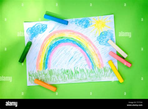 Children Drawing Rainbow Colored Crayons On A Bright Green Background