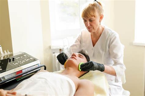 The Cosmetologist Makes The Procedure Ultrasonic Face Peeling Stock