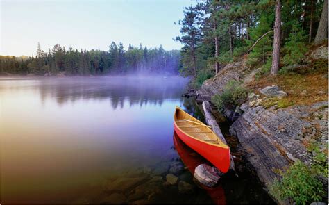 Calm Lake With A Red Canoe Wallpaper