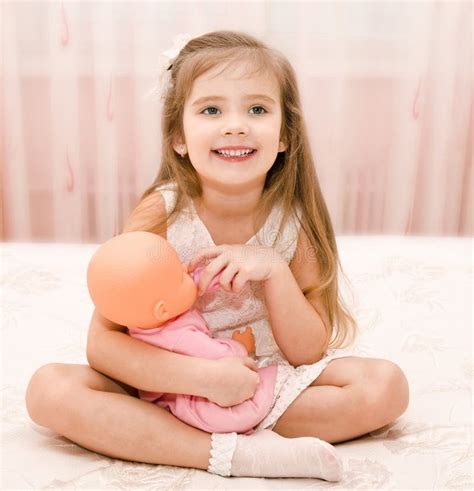 Niña Sonriente Linda Que Juega Con Una Muñeca Imagen De Archivo Imagen De Feliz Cama 38747761