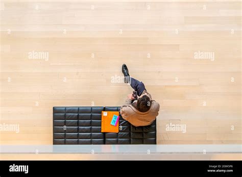 Top View Of Man Sitting On Vinyl Seat On Cell Phone In New York Art Gallery Stock Photo Alamy