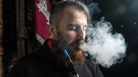 Pria Dengan Jenggot Besar Dan Potongan Rambut Modis Menghisap Rokok Elektronik Atau Hookah
