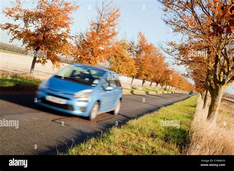 A Blue Car Driving On A Country Roads Roads In Autumn Cambridgeshire