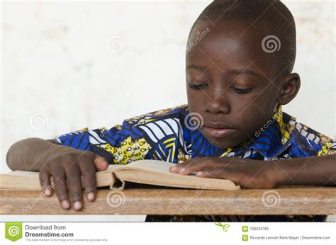 Little African Boy Reading Big Book At School With Copy Space Stock
