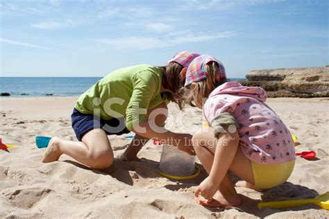 foto de stock niñas jugando con la arena en la playa libre de derechos freeimages