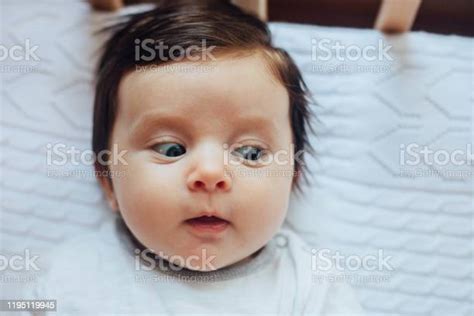 Surprised Cute Baby With Blues Eyes Close Portrait Lying In Bed Stock