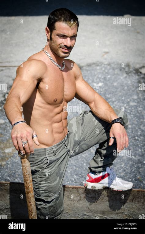 sexy construction worker shirtless showing muscular naked torso abs and chest outdoors stock