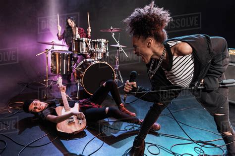 Young Multiethnic Rock And Roll Band Performing Concert On Stage
