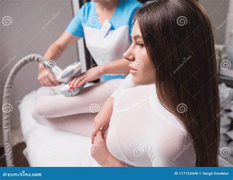 Female Having Procedure Of Massage On Legs In Apparatus Cosmetology Clinic Woman In Special