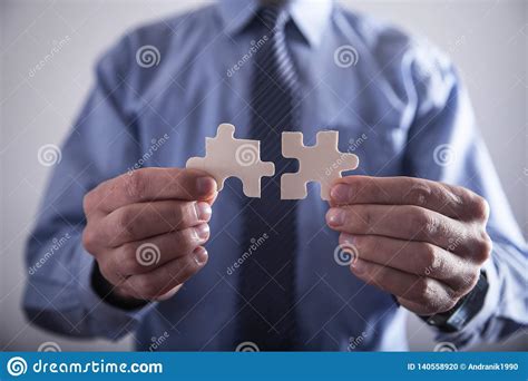 Businessman Holding Two Jigsaw Puzzle Piece Success And Business Stock