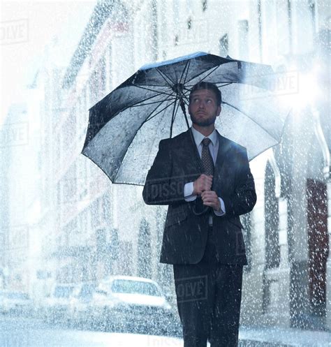 Businessman Under Umbrella In Rainy Street Stock Photo Dissolve