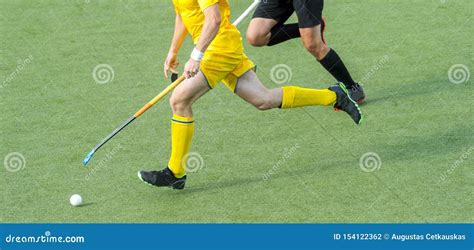 Two Field Hockey Player Fighting For The Ball On The Midfield During