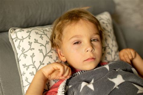 Toddler Child With Conjuctivitis Lying In Bed With Red Eyes