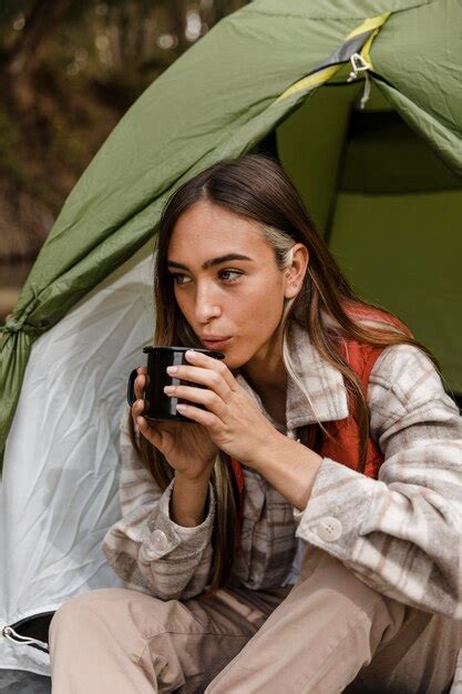 free photo happy camping girl in the forest blowing into a mug