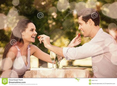 Couple Feeding Strawberries To Each Other At Outdoor CafÃ© Stock