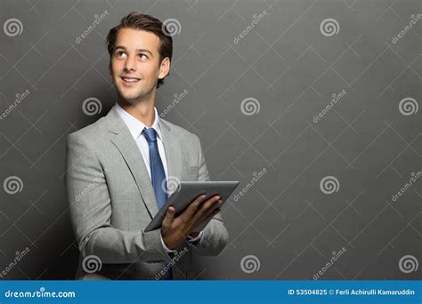 Young Businessman Thinking While Holding A Tablet Stock Image Image