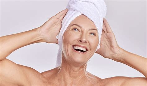 relaxed mature caucasian woman wearing a towel on her head after enjoying a refreshing shower