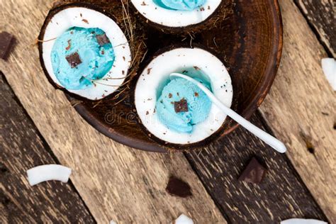 Blue Ice Cream With Chocolate In Coconut Bowl On Wooden Background