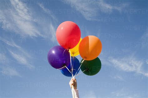 Hand Holding Helium Balloons Stock Photo
