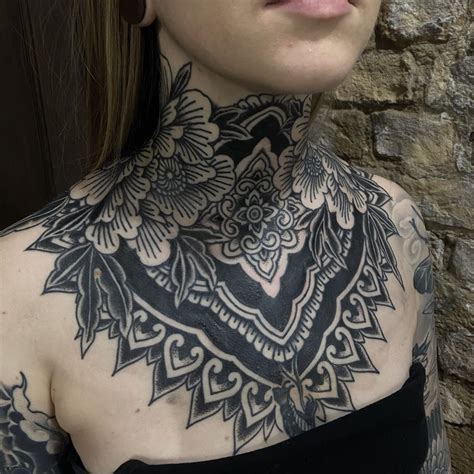 A Woman With Tattoos On Her Neck And Chest