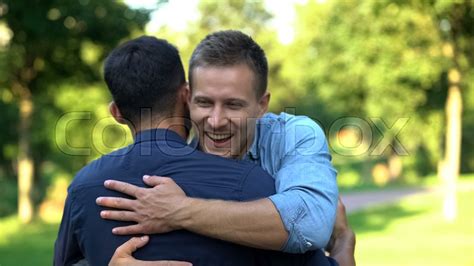 Two Male Friends Hugging Outdoors Stock Image Colourbox