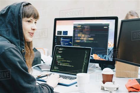 Side View Of Female Computer Programmer Looking Away While Using Laptop