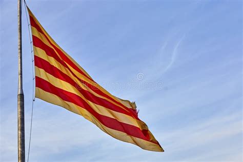 Flying Flag Of Catalonia Against Blue Sky Catalonia Flag Waving