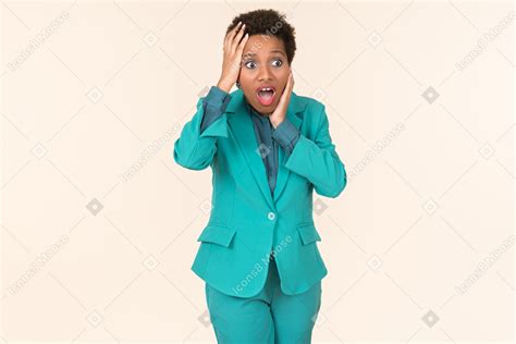 Фото Негритянка с короткой стрижкой одетая во все синие стоящая на простом пастельном фоне