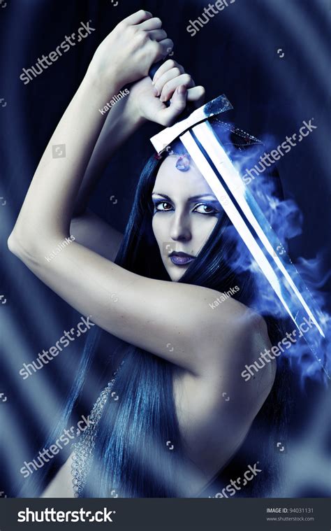 Young Sexy Woman Warrior Holding Blue Fire Sword In Hands
