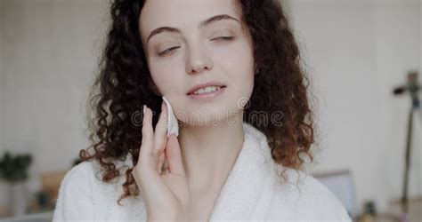Young Brunette Woman Removing Makeup From Her Face With Cotton Pad