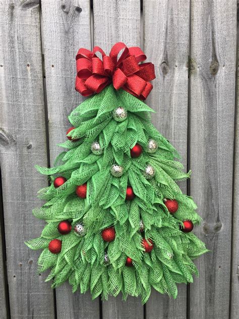 a christmas tree made out of green leaves and red bows on top of a