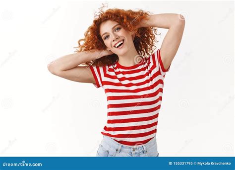 lively happy joyful redhead silly feminine curly haired girl playing hair touching curls smiling